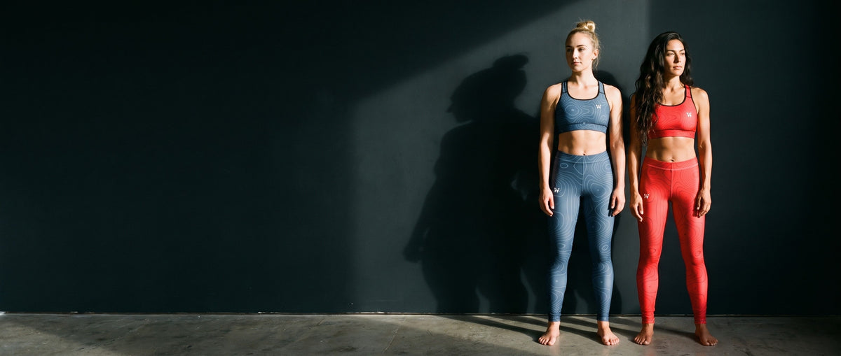 Two women in Sculpt Bras and Leggings in Cobalt and Cinnabar